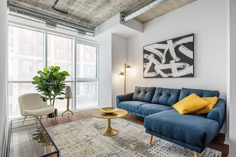 a living room with a blue couch and yellow pillows